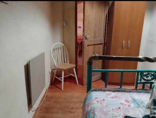 Habitación con cama, silla y puerta en La bodeguita-casa rural en Chilecito
