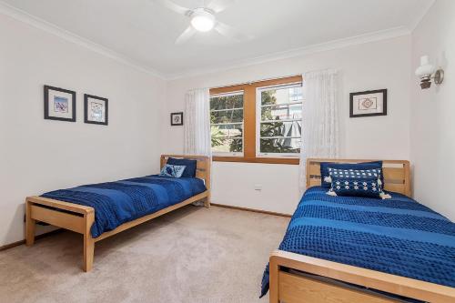 a bedroom with two beds and a window at Retro Beach House in Crescent Head