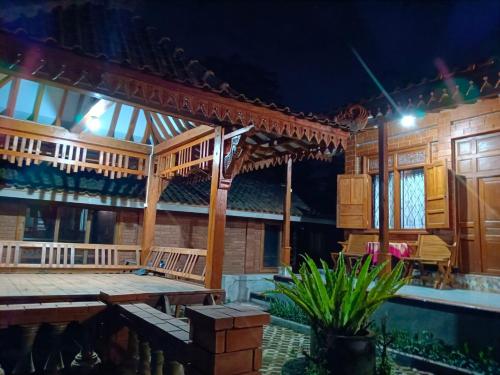 um grande edifício de madeira com um palco à noite em Guesthouse Jogja Omah Punagi em Sleman