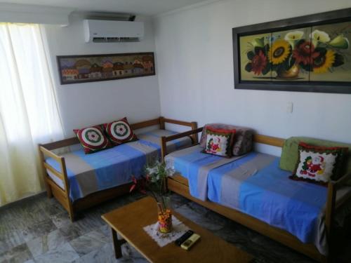 ein Wohnzimmer mit zwei Betten und einem Tisch in der Unterkunft Cartagena de Indias, Mar, historia y diversión ! in Cartagena de Indias