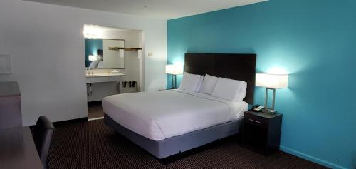 a hotel room with a bed and a bathroom at Travelodge by Wyndham Livonia Canton Novi Detroit Area in Livonia