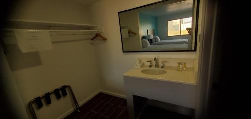 a bathroom with a sink and a mirror at Travelodge by Wyndham Livonia Canton Novi Detroit Area in Livonia