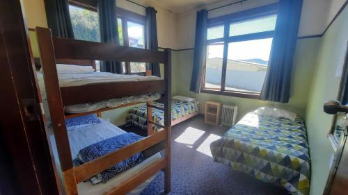1 dormitorio con 2 literas y ventana en Manor house backpackers en Dunedin