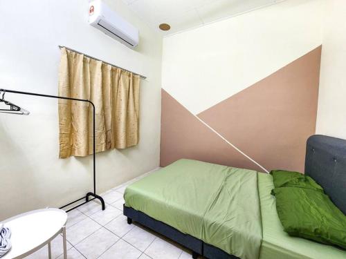 ein Schlafzimmer mit einem Bett, einer Lampe und einem Tisch in der Unterkunft Taiping Homestay Near Lakegarden in Taiping
