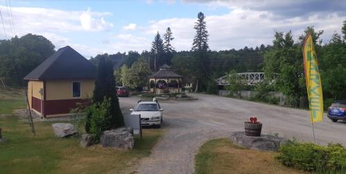 Un coche aparcado en un aparcamiento junto a un edificio. en Burnt River Bungalow, en Kinmount