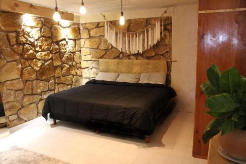 a bedroom with a bed in a stone wall at DEPARTAMENTO CENTRO SAN CRISTOBAL Estacionamiento lugares publicos en la calle in San Cristóbal de Las Casas