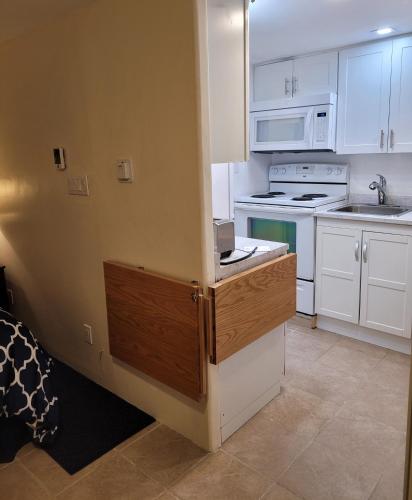 a small kitchen with white cabinets and a sink at Noble Waterfront Suites in Brockville