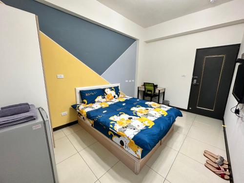 a bedroom with a bed with a blue comforter at 週週客棧 in Chia-hsiu