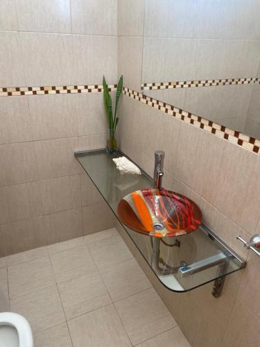 a bathroom with a glass sink and a toilet at Casa Daval solo Familias in Villa Carlos Paz