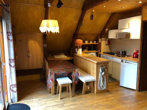 une petite cuisine avec une table et des chaises. dans l'établissement Chalet cosy avec terrasse exposée sud - 2km du centre, 2 chambres, 4 pers, parking privé. - FR-1-737-52, à Autrans