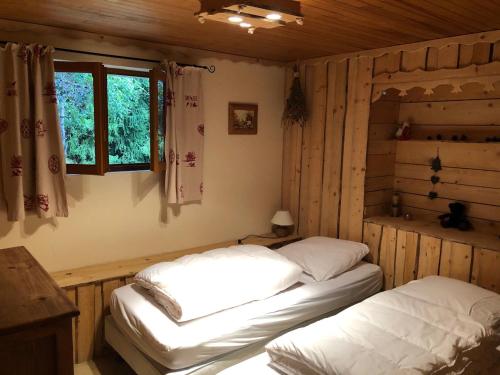 2 Betten in der Ecke eines Zimmers mit Fenster in der Unterkunft Chalet cosy avec terrasse exposée sud - 2km du centre, 2 chambres, 4 pers, parking privé. - FR-1-737-52 in Autrans