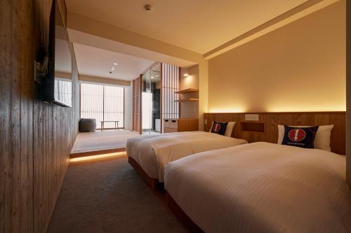THE HOTELS HAKATA Harushige Honkan في فوكوكا: غرفة فندقية بسريرين ونافذة