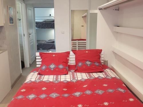 - une petite chambre avec des oreillers rouges et un lit dans l'établissement Studio Autrans-Méaudre en Vercors-Autrans, 1 pièce, 4 personnes - FR-1-737-8, à Autrans