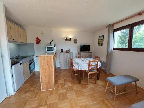 une cuisine et une salle à manger avec une table et des chaises dans l'établissement Duplex lumineux de 55m² à Autrans - 6 pers - Pieds des pistes, proche commerces et navette ski - FR-1-737-21, à Autrans