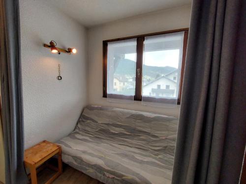 une petite chambre avec un lit et une fenêtre dans l'établissement Charmant Appartement à Autrans - 4 pers, 32m², près du centre et des pistes de ski - FR-1-737-25, à Autrans