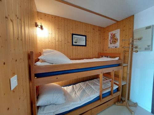 two bunk beds in a room with wooden walls at Appartement cosy à Méaudre - 2 chambres, 5 pers, parking, lave-linge - FR-1-737-39 in Méaudre