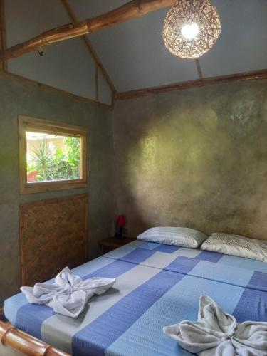 a bedroom with a bed with towels on it at Yucca Bungalow in El Nido