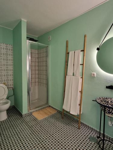 a bathroom with a shower and a toilet and towels at Wonder Charm Guesthouse in Albufeira