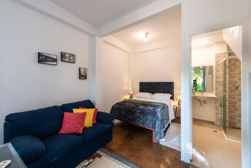 a living room with a blue couch and a bed at Happy Sweet Home 3 in Sao Paulo