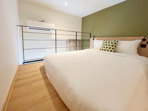 a bedroom with a large white bed and a window at Coliwoo 298 River Valley - CoLiving in Singapore