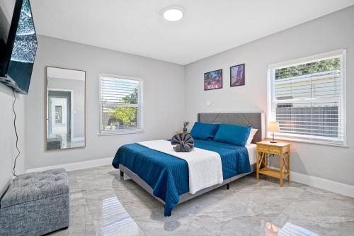 a bedroom with a blue bed and two windows at Miami Lux Vacations - Villa in Miami