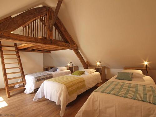 une chambre avec deux lits et un parquet dans l'établissement Gîte confortable avec jardin privatif, 4 chambres, étang, animaux, à Céaucé - FR-1-497-6, à Céaucé