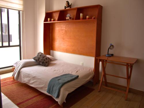 - une chambre avec un lit doté d'une tête de lit en bois et d'une table dans l'établissement Private condominium in Mexico City: 2B 2B, à Mexico