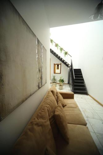 a bedroom with a large couch in a room with stairs at DEPA REMODELADO CENTRO HISTÓRICO ROOF GARDEN CON ESTACIONAMIENTO in Zacatecas