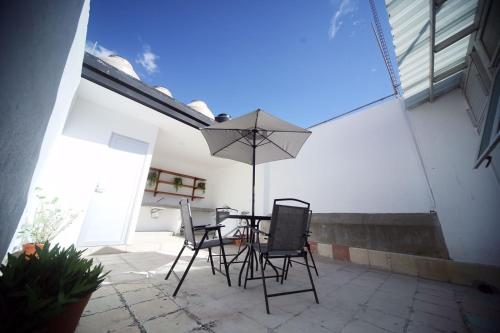 a patio with a table and chairs and an umbrella at DEPA REMODELADO CENTRO HISTÓRICO ROOF GARDEN CON ESTACIONAMIENTO in Zacatecas