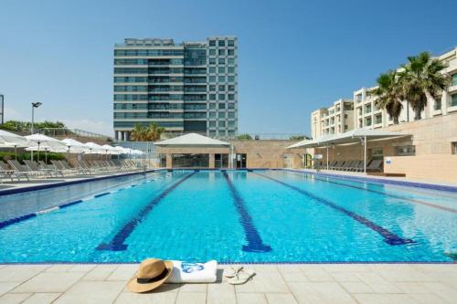 a large swimming pool with a hat on the side at Okeanos Bmarina in Herzliya B