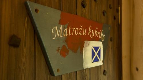 a sign on a wooden wall with the words michigan buildings at Viesu nams Melnsils in Melnsils