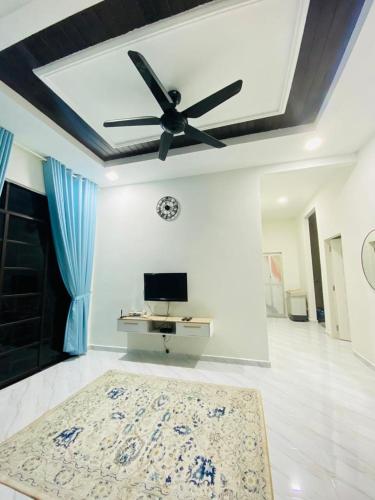 a living room with a ceiling fan and a rug at Homestay D Twinz (2 unit semi d) in Kuala Berang