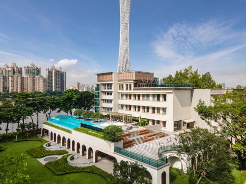 a hotel with a swimming pool in front of a building at Hotel Indigo Guangzhou Haixinsha, an IHG Hotel - Social hour at Flow in Guangzhou