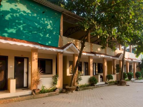 馬諾麗的住宿－OYO Manori Resort，庭院里一排种有树木的建筑