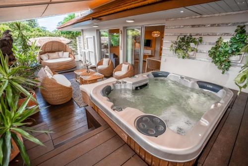 a jacuzzi tub on a deck with a patio at H&ocirc;tel Le Lagon in Noumea