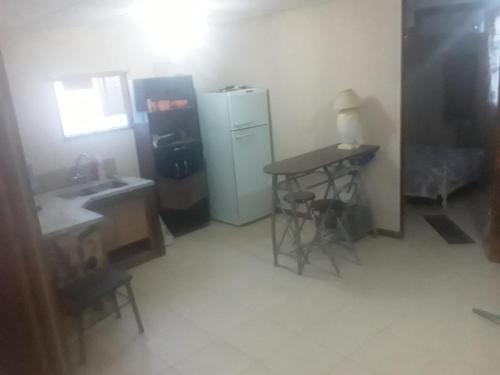 eine kleine Küche mit einem Tisch und einem Kühlschrank in der Unterkunft Casa in Pocito