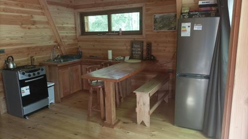 a kitchen with a wooden table and a refrigerator at Casa Aurora in Puerto Fuy