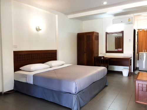 1 dormitorio con cama, lavabo y escritorio en Suansin Garden Hotel โรงแรมสวนสินการ์เด้น, en Tak