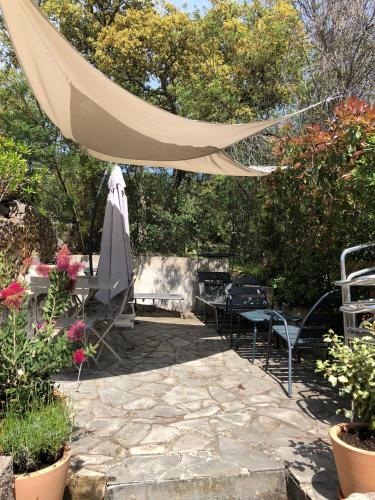 une terrasse avec un parasol, des chaises et des plantes dans l'établissement Capitou, à Fréjus