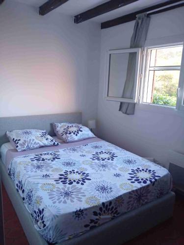 - un lit avec une couette bleue et blanche et une fenêtre dans l'établissement Capitou, à Fréjus