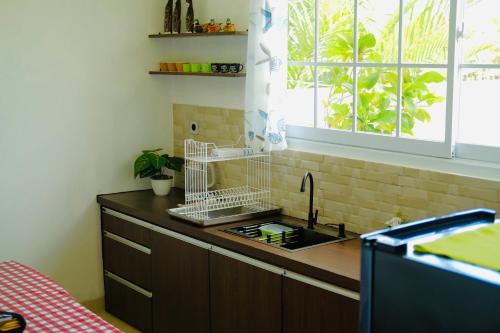 a kitchen counter with a sink and a window at Saint Cottage River Side in Batukaras