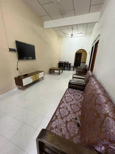 a living room with a couch and a flat screen tv at Hajjah Homestay Jln Rajawali Tg Agas in Muar