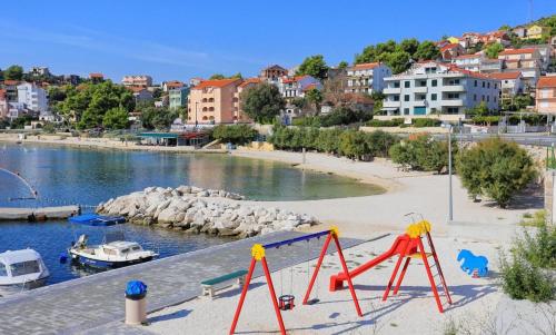 a playground on a beach next to a body of water at Apartmani Ines in Marina