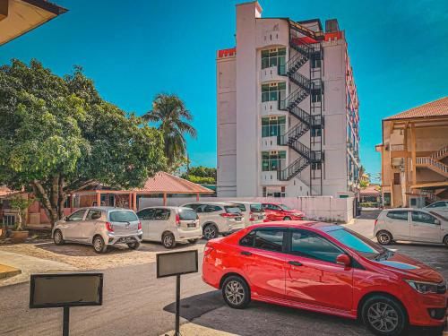 a red car parked in front of a building at Amzar Motel Cenang in Pantai Cenang