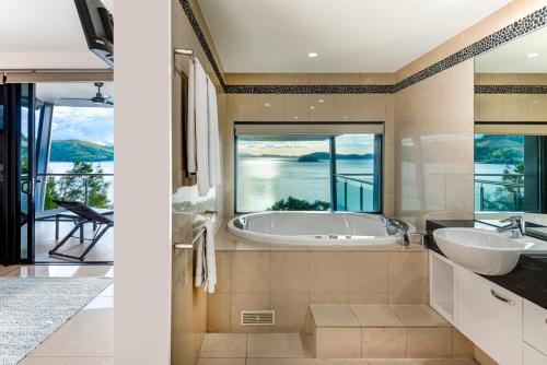baño con 2 lavabos y bañera con vistas en Edge Penthouse on Hamilton Island by HIHA en Isla Hamilton