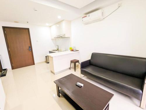 a living room with a black couch and a table at Lovina 1811 Harbourbay Residence in Batu Ampar