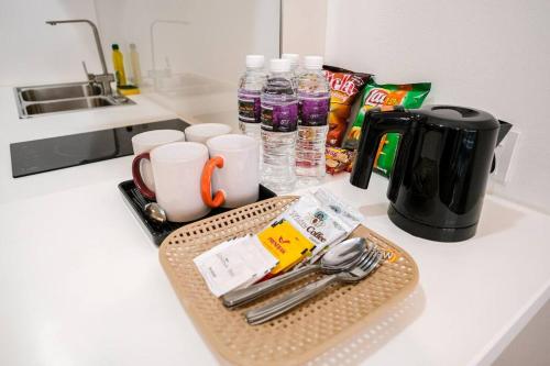 a kitchen counter with a tray with utensils on it at Lovina 1811 Harbourbay Residence in Batu Ampar