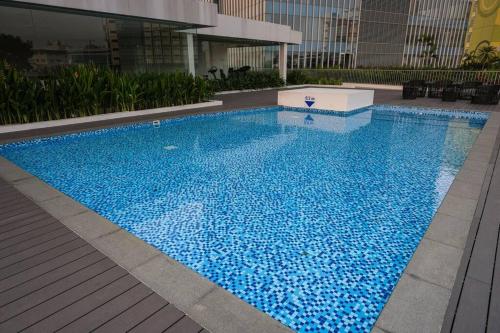 a large blue swimming pool in a building at Lovina 1811 Harbourbay Residence in Batu Ampar
