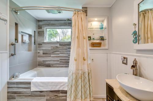 La salle de bains est pourvue d'une baignoire et d'un lavabo. dans l'établissement Walworth Home with Hot Tub - Near Golf Courses!, 