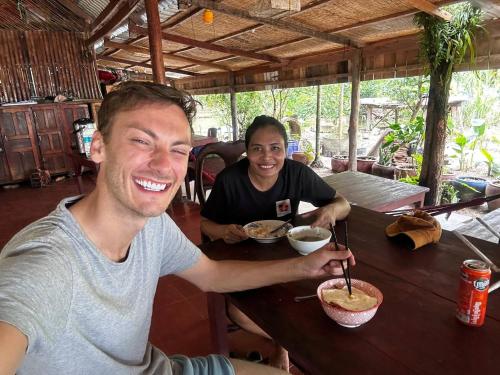 a couple of people sitting at a table eating food at Mangrove Beach Bungalows in Koh Rong Sanloem